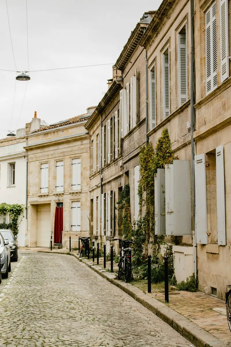 Rue pavée bordée de façades en pierre blonde, aux Chartrons
